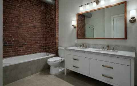 Chelsea loft bathroom renovation Manhattan - industrial luxury design with exposed brick and modern fixtures